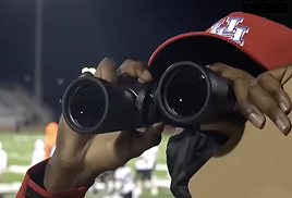 Olheiro observando o campo com um binóculo.